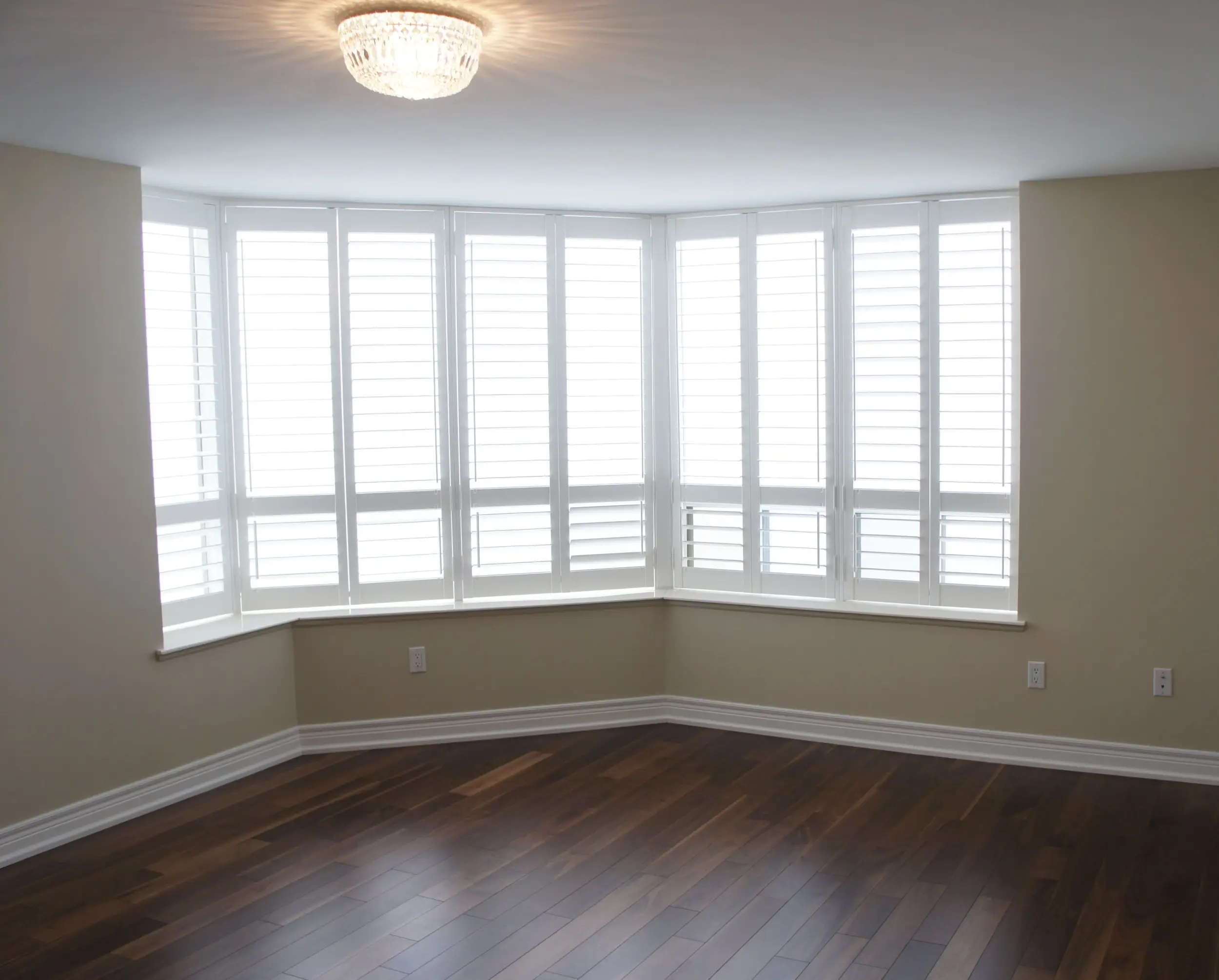 wood shutters in bay window of a condo bedroom
