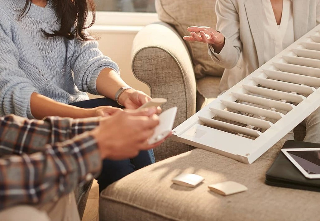 in home design consultation showing samples of window shutters to young couple